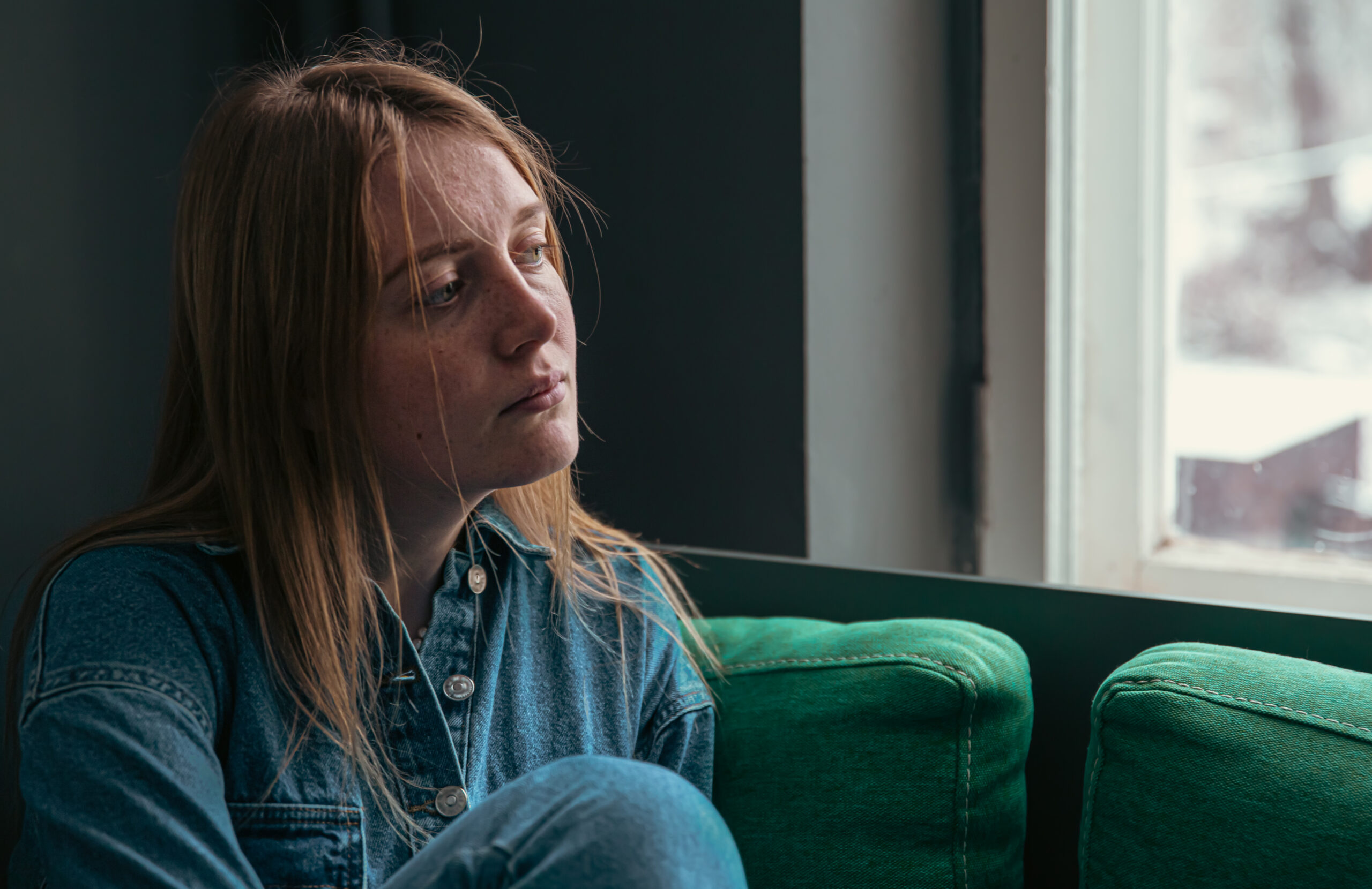 sad bereaved woman sitting on a sofa - congleton funeral directors