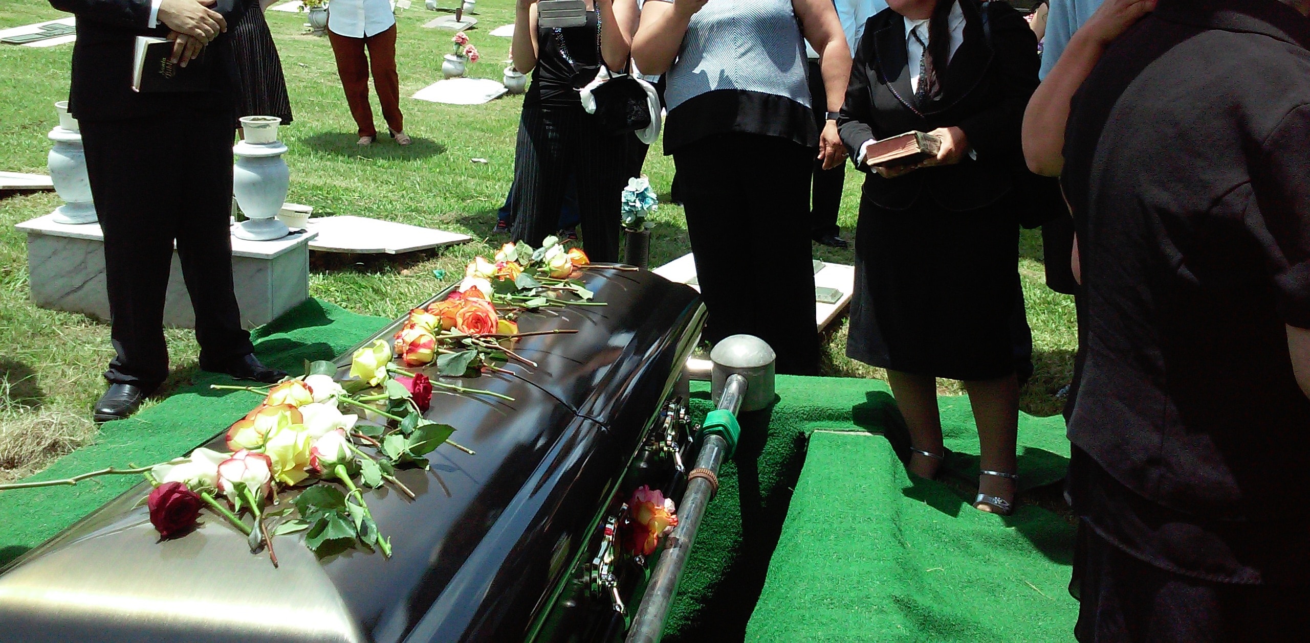 funeral directors in congleton - flowers on coffin. funeral attended by mourners